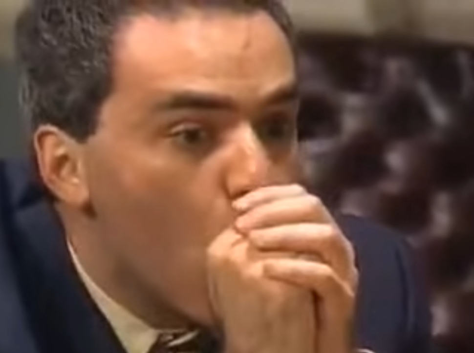 Garry Kasparov clasps his hands in front of his mouth while considering Deep Blue