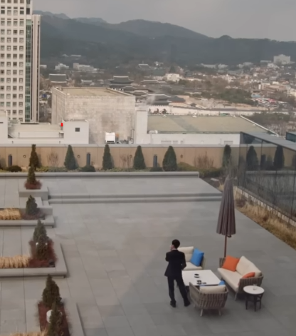 Lee Sedol stands alone on a terrace during a cigarette break from the AlphaGo match